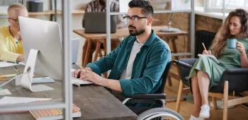 Une homme en fauteuil roulant travaillant dans un bureau